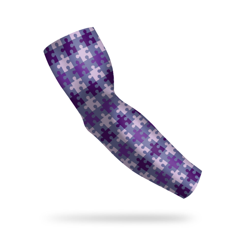 Photo of a sleeve decorated with puzzle pieces in various shades of purple on a white background.