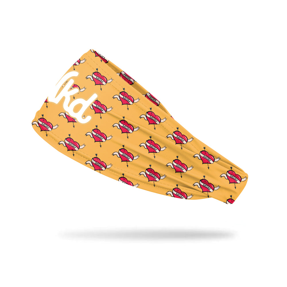 Photo of a yellow headband with a mom heart icon on a white background.