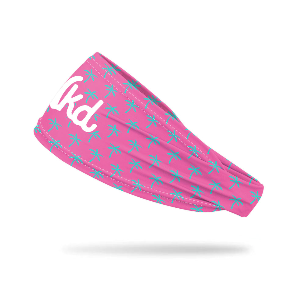 Photo of a pink headband decorated with a light blue palm tree on a white background.