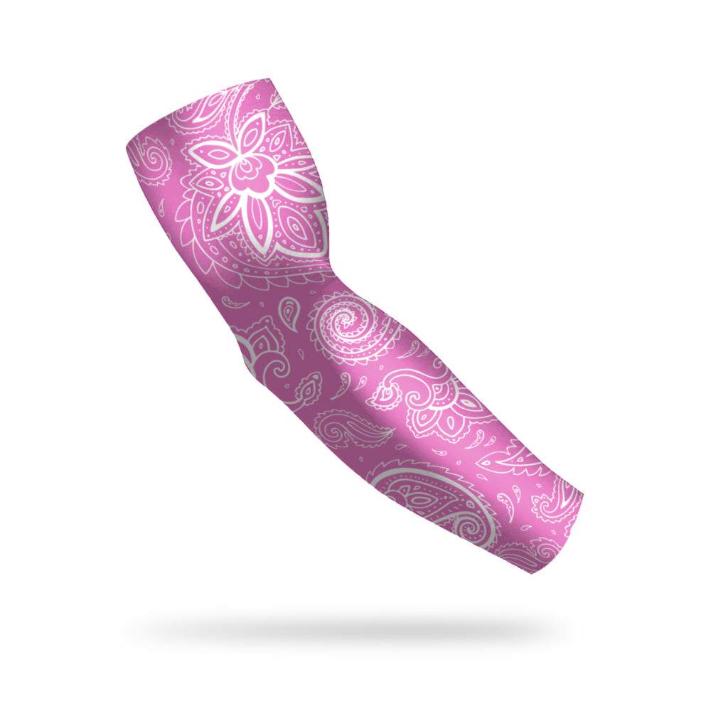 photo of a pink compression sleeve with a white paisley pattern decorating it floating on a white background.