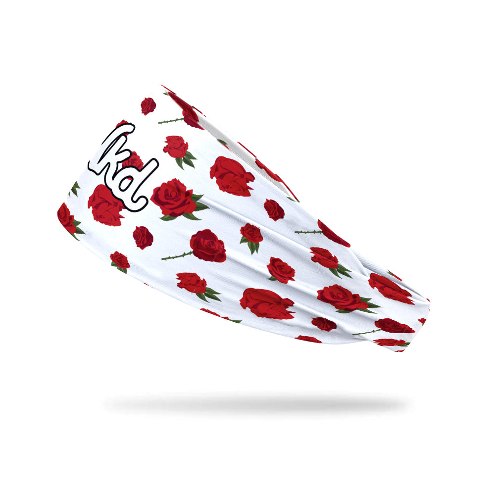 Photo of the side view of a white headband decorated with roses on a white background.