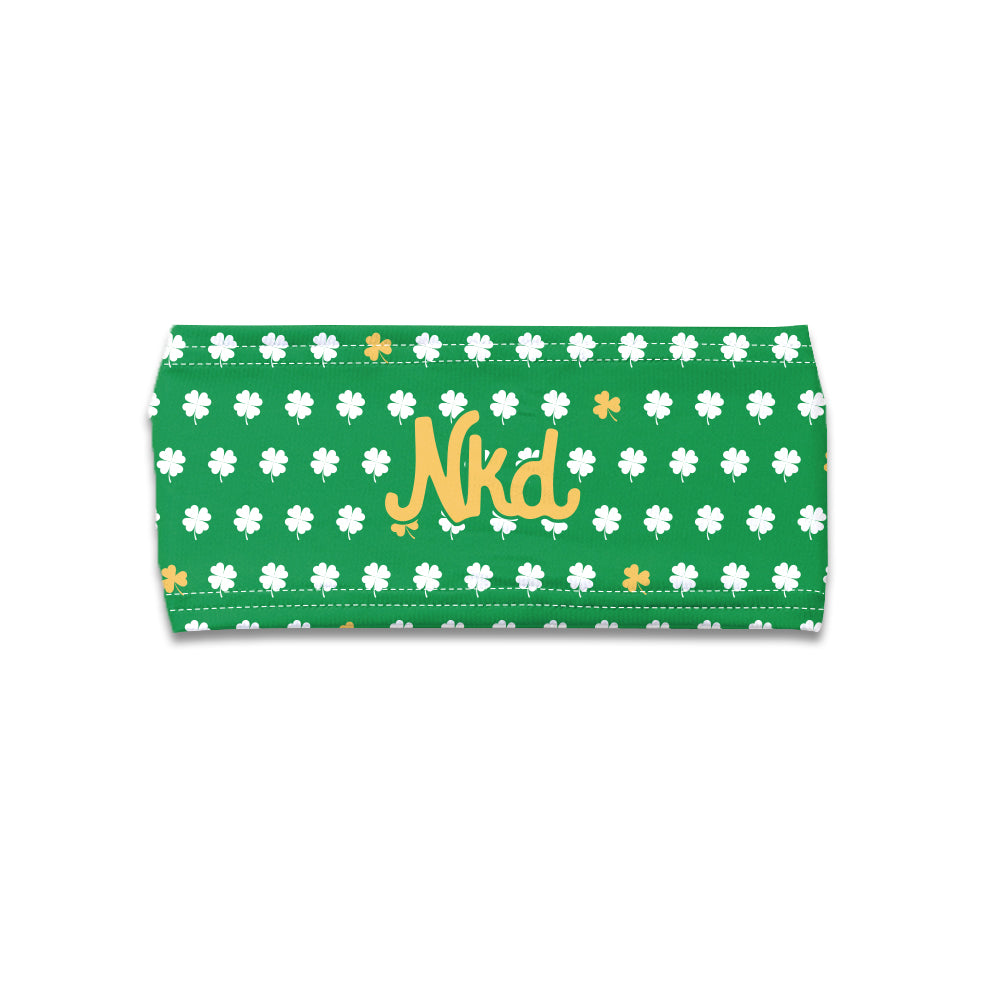 Photo of a green headband decorated with a white and gold shamrock and NKD logo in the middle on a white background.