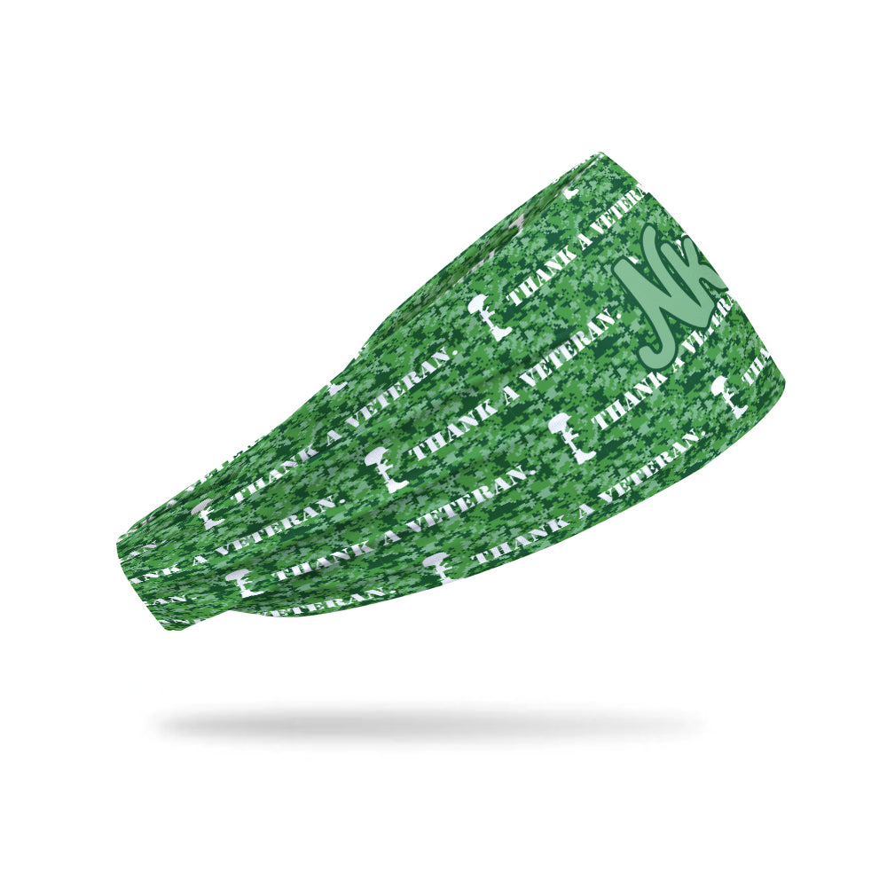 Photo of a headband decorated with digital camouflage in various shades of green with the words Thank a veteran written on it.