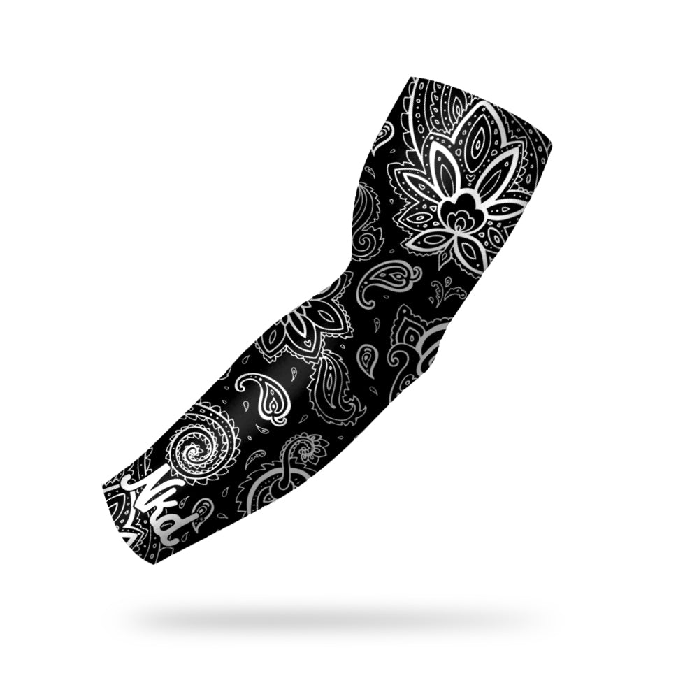 photo of a black compression sleeve with a white paisley pattern decorating it floating on a white background.