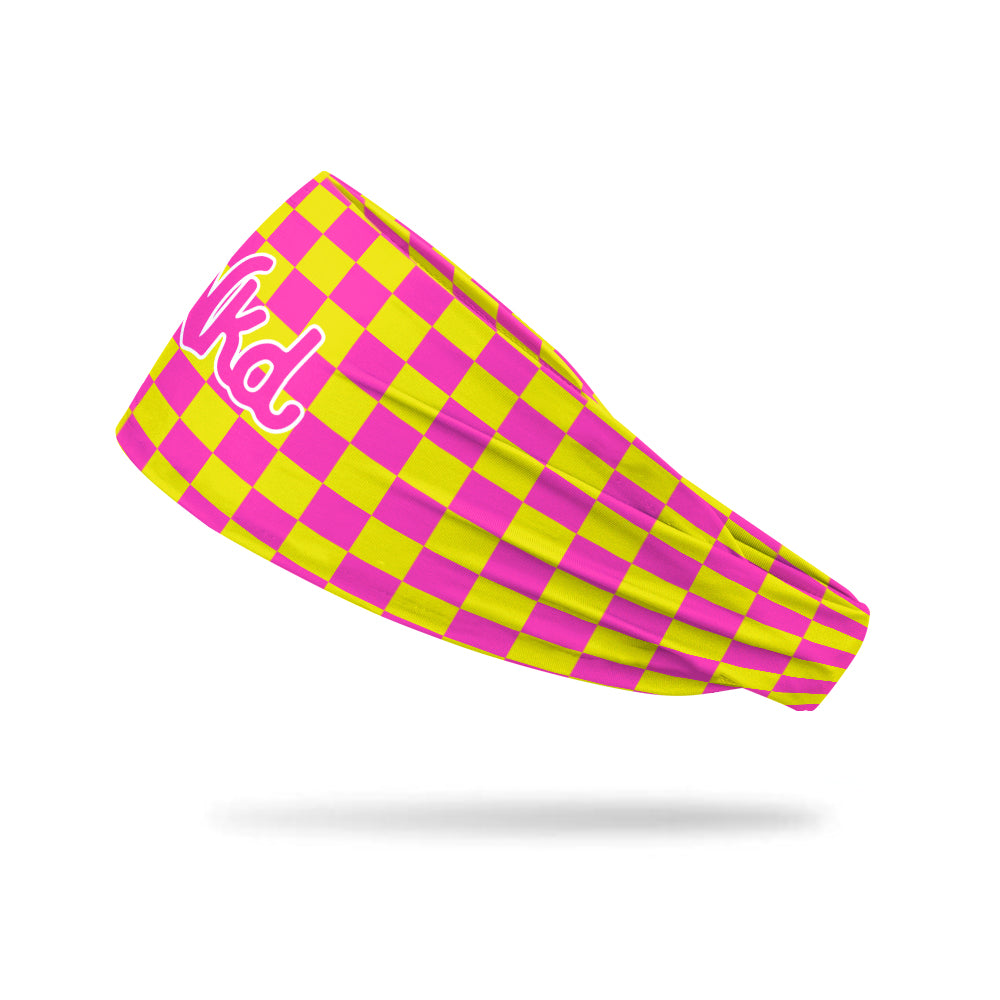 Photo of a headband with a pink and yellow checkerboard pattern floating on a white background.