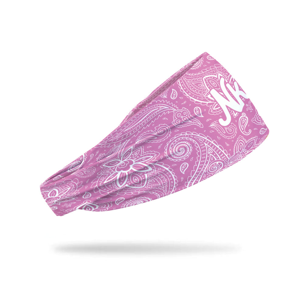 Photo of pink headband decorated a white paisley pattern floating on a white background.