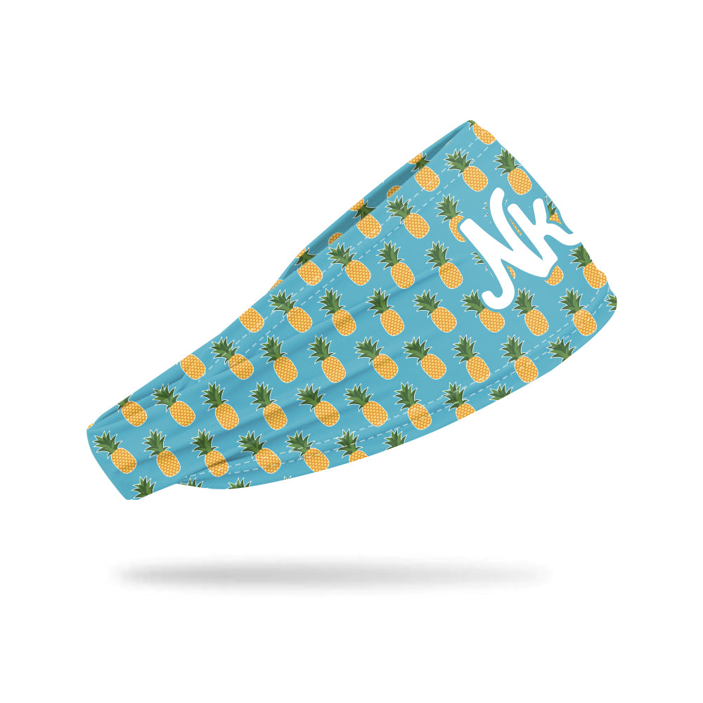 Photo of a blue headband with a pineapple pattern printed on all over while floating on a white background. 