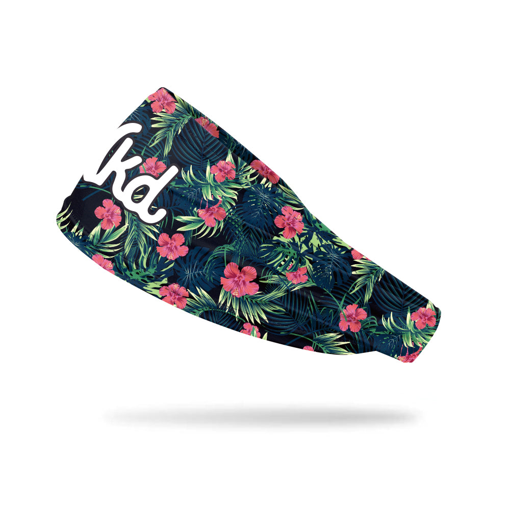 Photo of a black headband with a tropical pattern floating on a white background.