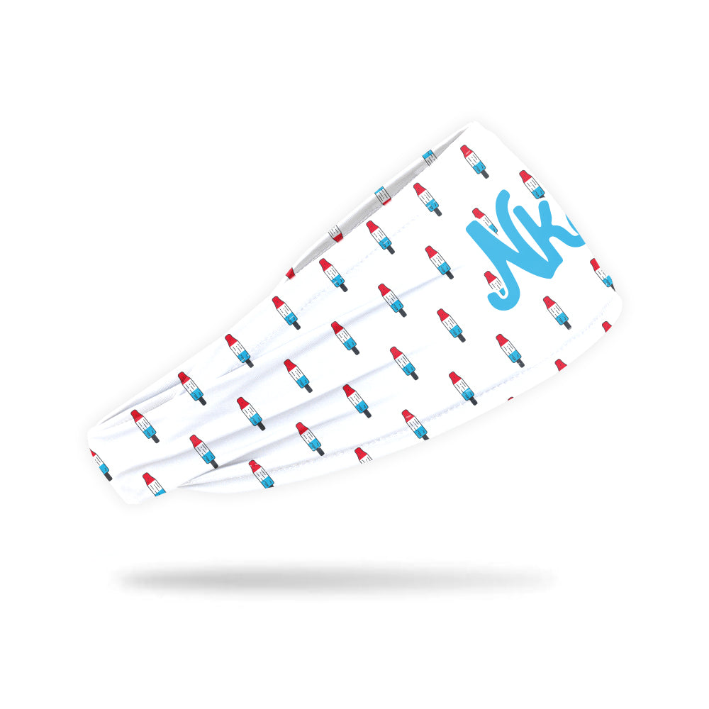 Photo of a white headband with a popsicle icon decorating it floating on a white background. 