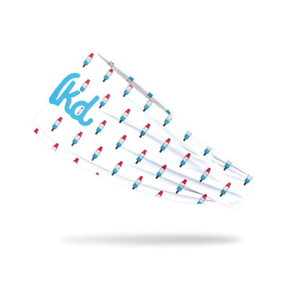 Photo of a white headband with a popsicle icon decorating it floating on a white background.